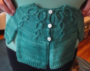 Teal baby sweater with three white buttons