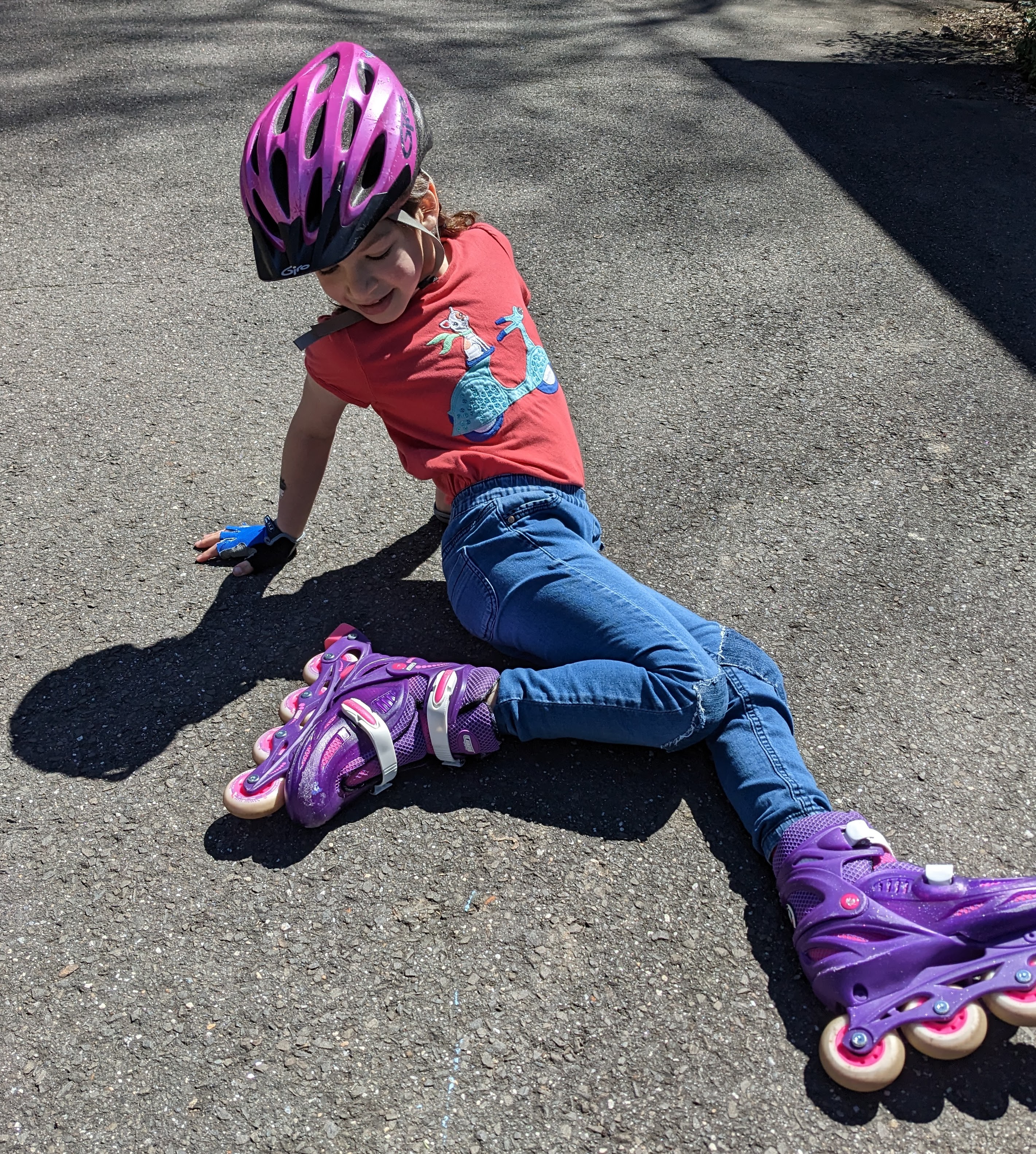 Kid in pink helmet and purple rollerblades